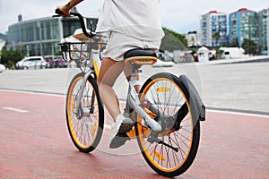 Young woman riding bicycle on lane in city, closeup