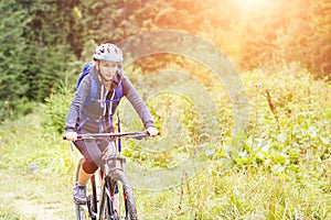 Young woman riding bicycle in mountain forest