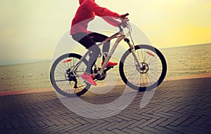 Young woman riding bike on seaside