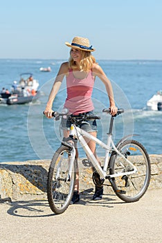 young woman riding bike on seaside