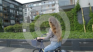 Young woman riding on bike in sunny day . Beautiful mood shot of young woman or girl riding bicycle in city. Girl with cerly hair