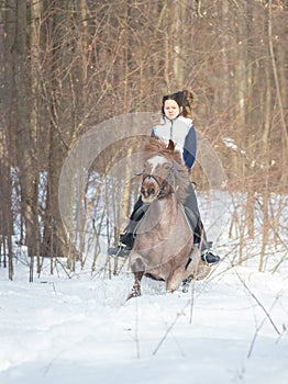 A young woman riding a brown horse