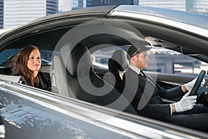 Young Woman Riding In A Car With Chauffeur