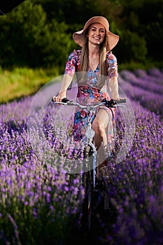 Young woman riding her bicycle in a lavender field