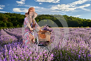 Young woman riding her bicycle in a lavender field