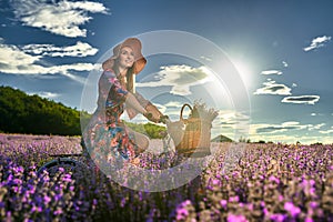 Young woman riding her bicycle in a lavender field