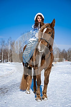 young woman riding a horse in winter