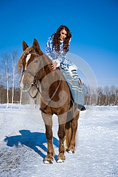 young woman riding a horse in winter