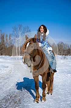 young woman riding a horse in winter