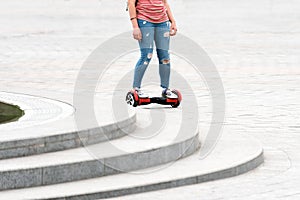 Young woman riding a hoverboard on the city square. New movement and transport technologies. Close up of dual wheel self