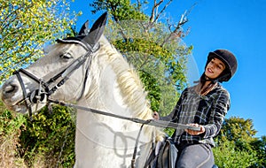 Young woman riding white horse