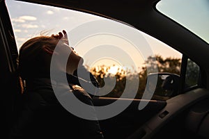Young Woman On Road Trip Vacation Driving And Looking Out Of Rental Car Window