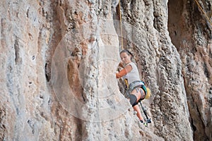 Young woman rock climbing on karst limestone white mountain in T