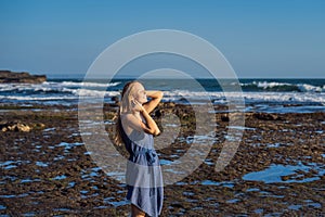 A young woman on a rocky cosmic Bali shore