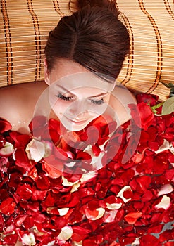 Young woman in rose petal swim water.