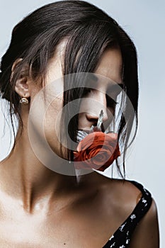 Young woman with rose in teeth