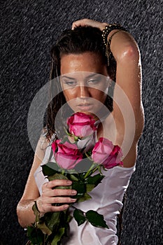 Young woman with roses under rain.