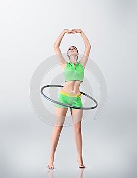 Young woman rotating hula hoop