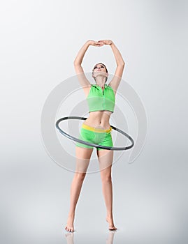 Young woman rotating hula hoop photo