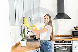 Young woman in rubber gloves doing house cleaning