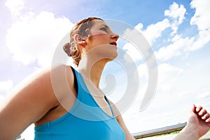 Young woman runing in the city over the brige in sun light.