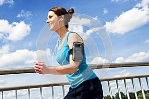Young woman runing in the city over the brige in sun light, smil photo