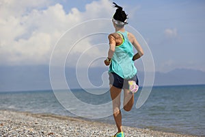 Young woman runner running on seaside