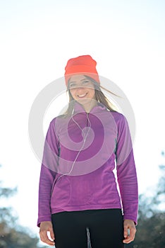 Young Woman Runner Smiling in Beautiful Winter Forest at Sunny Frosty Day. Active Lifestyle and Sport Concept.