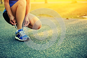 Young woman runner tying shoelaces