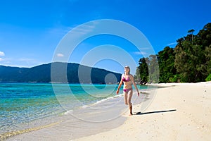 Young woman running along the beach