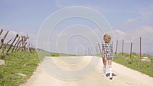 Young woman running along a rural dirt road