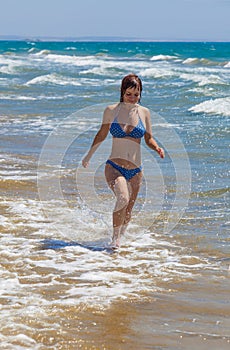 Young woman is running along the seaside