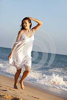 Young Woman Running Along Summer Beach