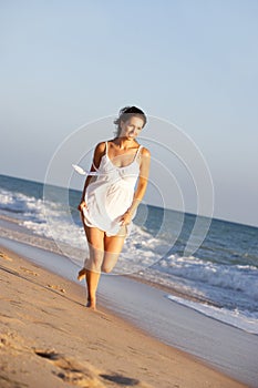 Young Woman Running Along Summer Beach