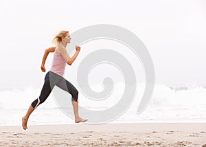 Young Woman Running Along Winter Beach