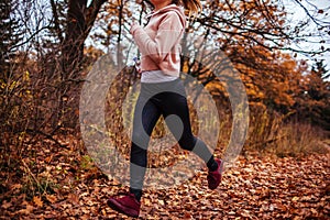 Young woman running in autumn forest