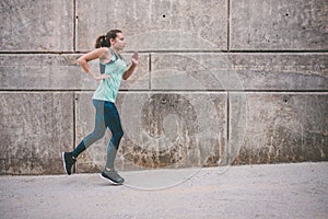 Young woman running away in an industrial scene, during sunrese.