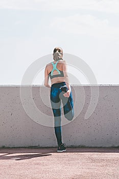 Young woman running away in an industrial scene, during sunrese.