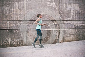 Young woman running away in an industrial scene, during sunrese.