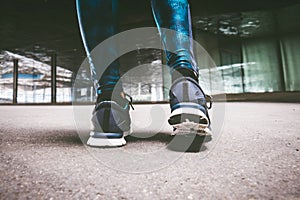 Young woman running away in an industrial scene, during sunrese.