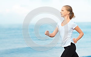 Young woman running on the beach on the coast of the Sea