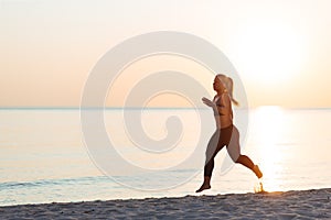 Young woman running on the beach photo