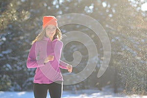 Young Woman Running in Beautiful Winter Forest at Sunny Frosty Day. Active Lifestyle Concept.