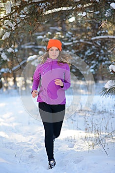 Young Woman Running in Beautiful Winter Forest at Sunny Frosty Day. Active Lifestyle Concept.