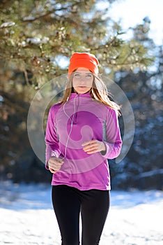 Young Woman Running in Beautiful Winter Forest at Sunny Frosty Day. Active Lifestyle Concept.