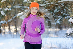 Young Woman Running in Beautiful Winter Forest at Sunny Frosty Day. Active Lifestyle Concept.