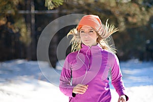 Young Woman Running in Beautiful Winter Forest at Sunny Frosty Day. Active Lifestyle Concept.