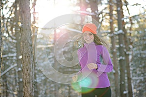 Young Woman Running in Beautiful Winter Forest at Sunny Frosty Day. Active Lifestyle Concept.