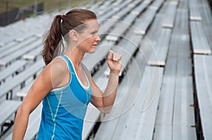 Young Woman Running on Bleachers at Outdoor Track