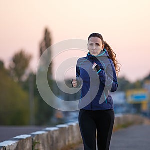 Young woman running on bridge in early morning